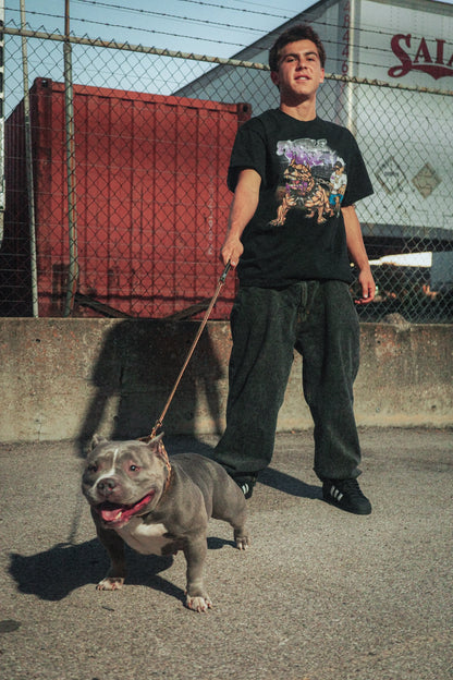Black t-shirt with full color graphic printed on the front. The graphic is a dude walking his pit bull, and holding a double cup. The pit bull has gold teeth, and Purple Wax looking drool. Purple Wax logo is shining at the top. Graphic made by Fiend. 

Purple Wax - 3rd Coast Skate Wax - Out the Mud Since 2014 - Skateboard Wax and Apparel